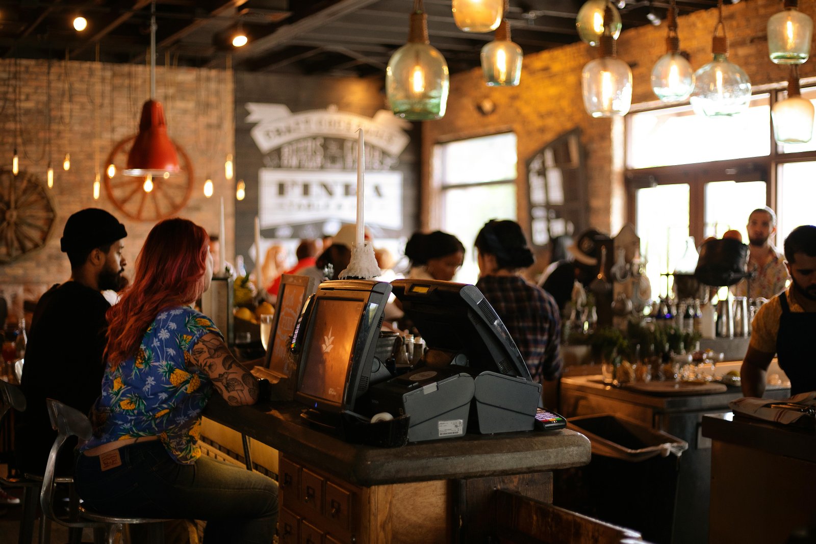 Bar scene with staff providing personalized customer service in a cozy, warmly lit atmosphere.
