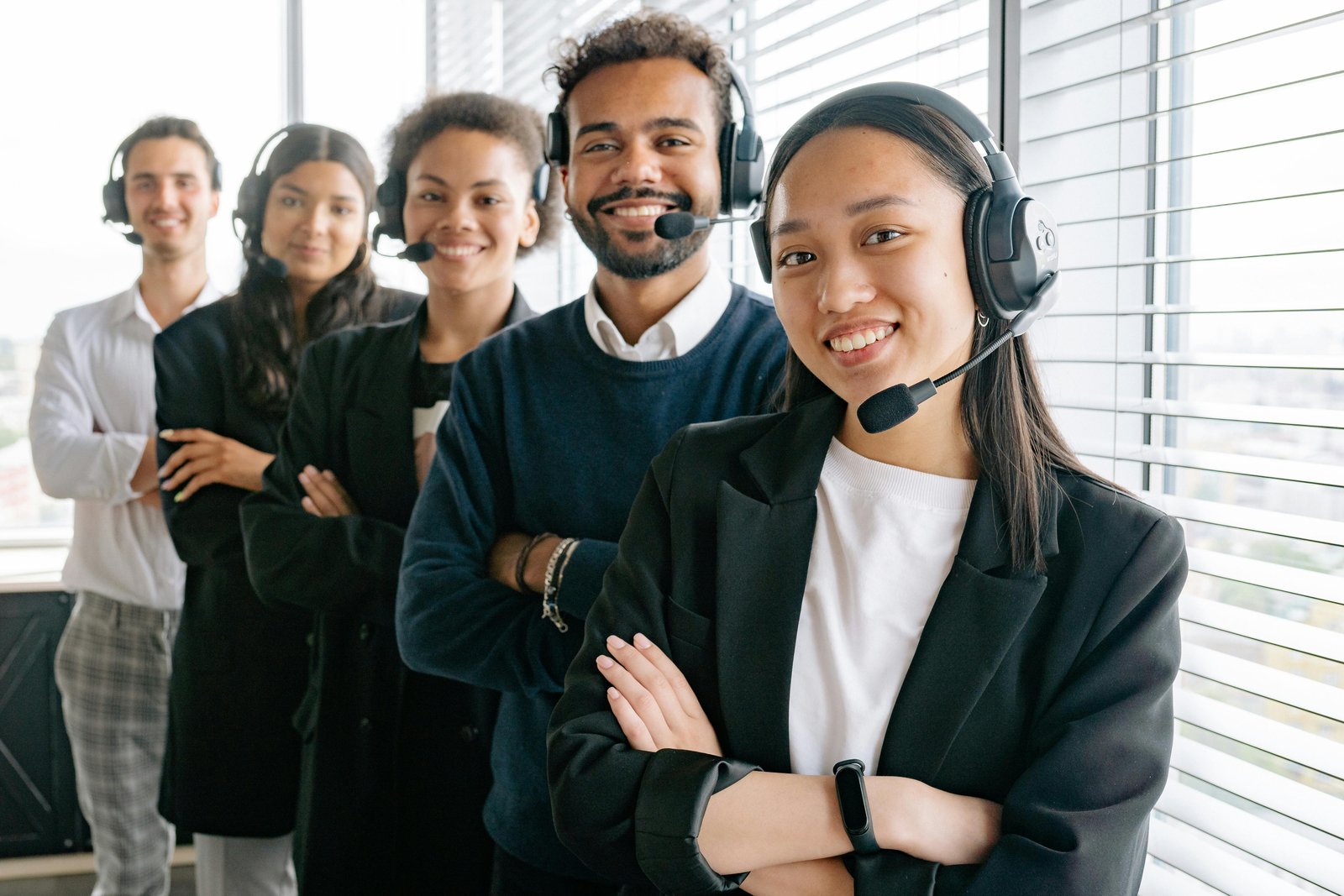 A diverse customer support team smiling while wearing headsets, representing a Customer-First Business.
