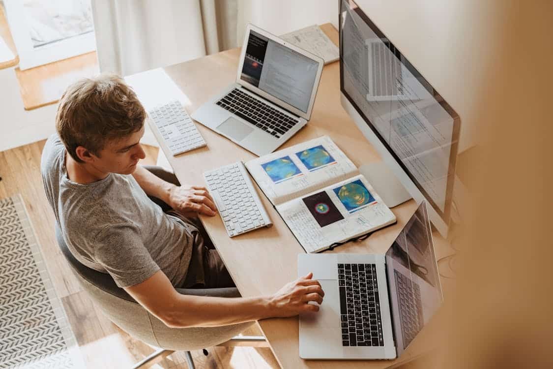 Man working with multiple devices on desk, highlighting Fair Labor Standards Act's Overtime Compensation.