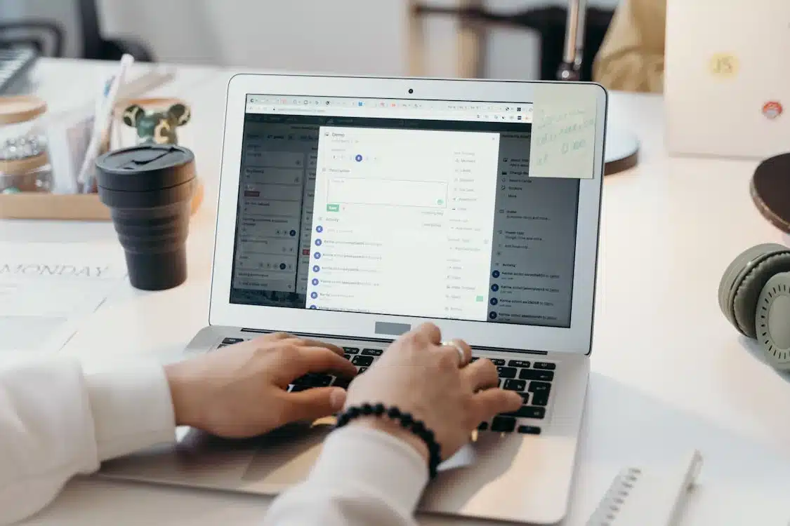 Hands typing on a laptop with a project management tool, symbolizing collaboration in Global Cross-Functional Teams.