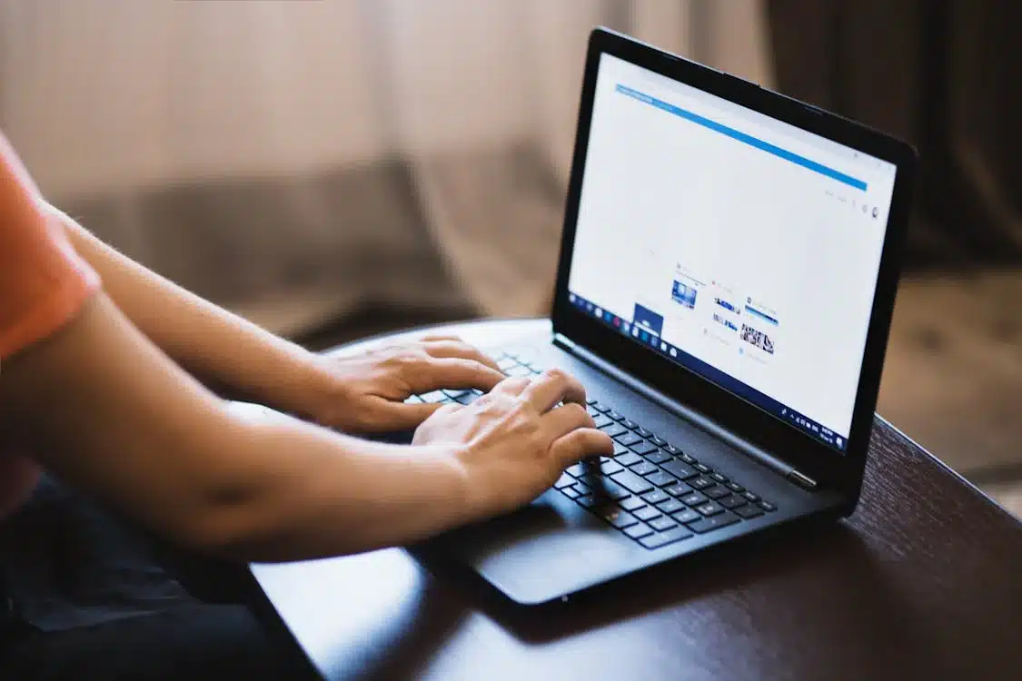 Person typing on a laptop, exploring strategies for 'Using Social Media for Small Business Success.