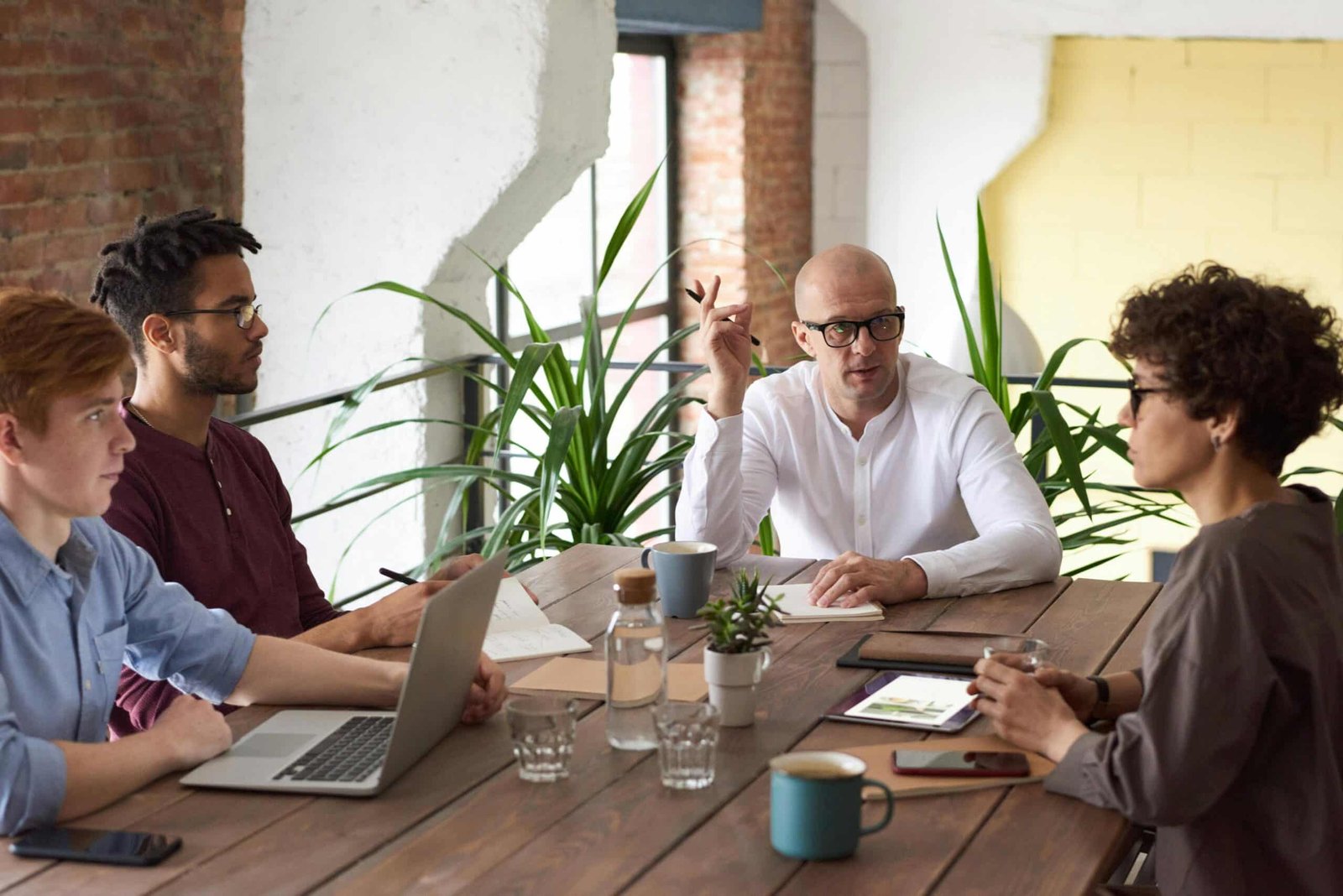 Team discussing strategies in a meeting room for Strategic Planning vs Tactical Planning.