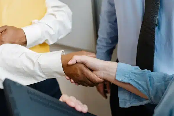 a close-up of a man shaking a woman's hand - DEI programs