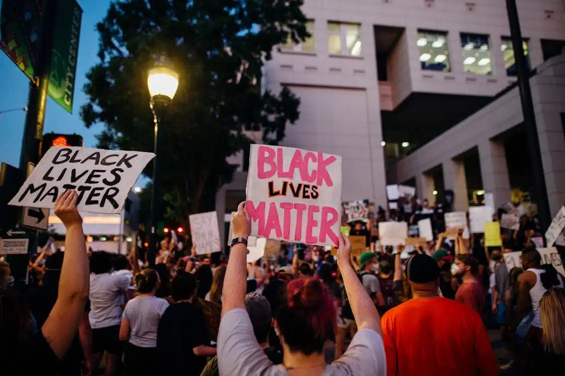 Crowd holding "Black Lives Matter" signs during a protest, representing social justice themes within the "Woke Political Spectrum.